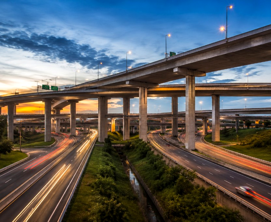 Highway interchange with light trails at dusk